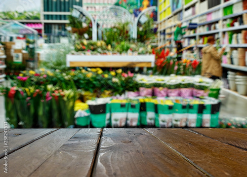 Shop of garden flowers. In the foreground is the top of a wooden table, counter. © serperm73