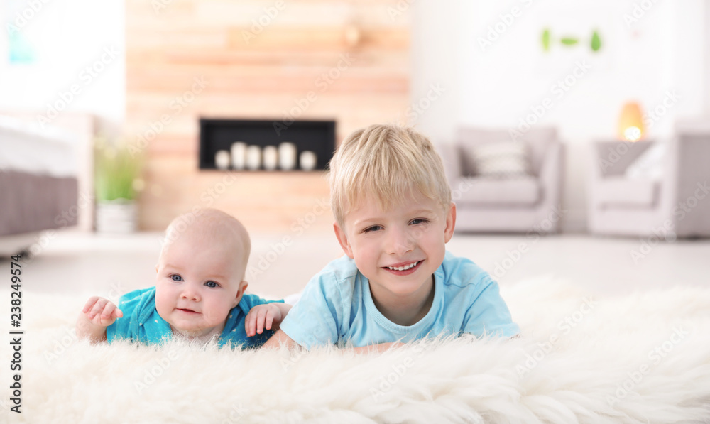 Cute boy with his little sister lying on fur rug at home Cute boy with his little sister lying on fur rug at home