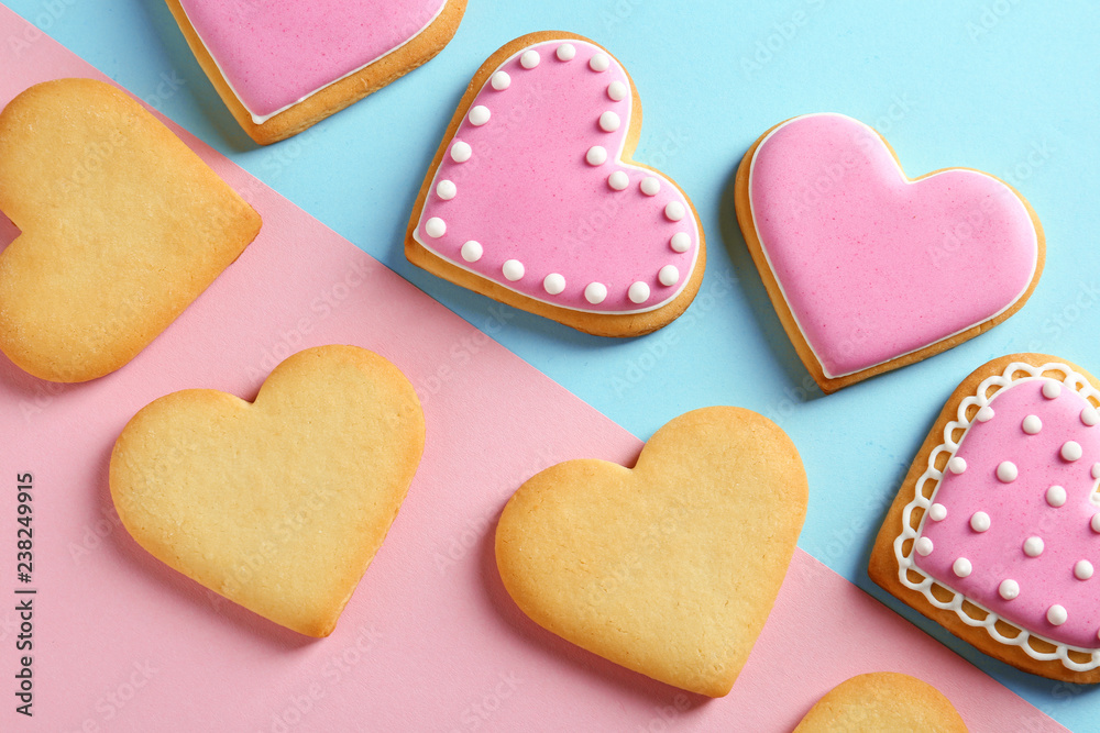 Fototapeta premium Decorated heart shaped cookies on color background, top view