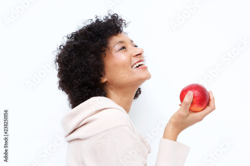 happy african american woman holding apple against white background