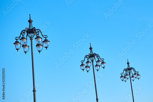 Wrought streetlamps on the background of blue sky