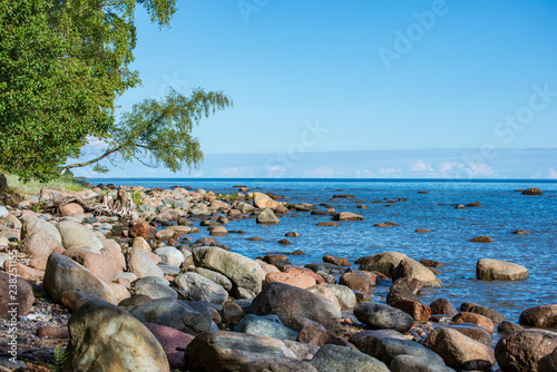 rock covered beach in countryside in Latvia, large rocks in water