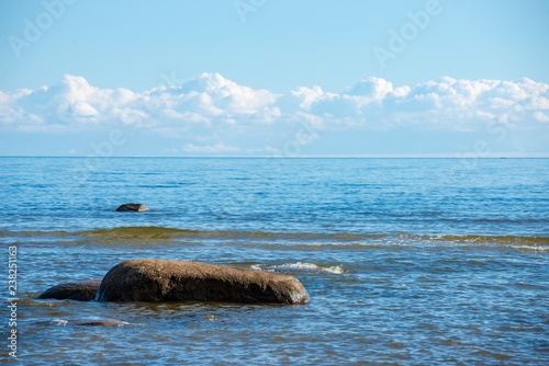 rock covered beach in countryside in Latvia, large rocks in water