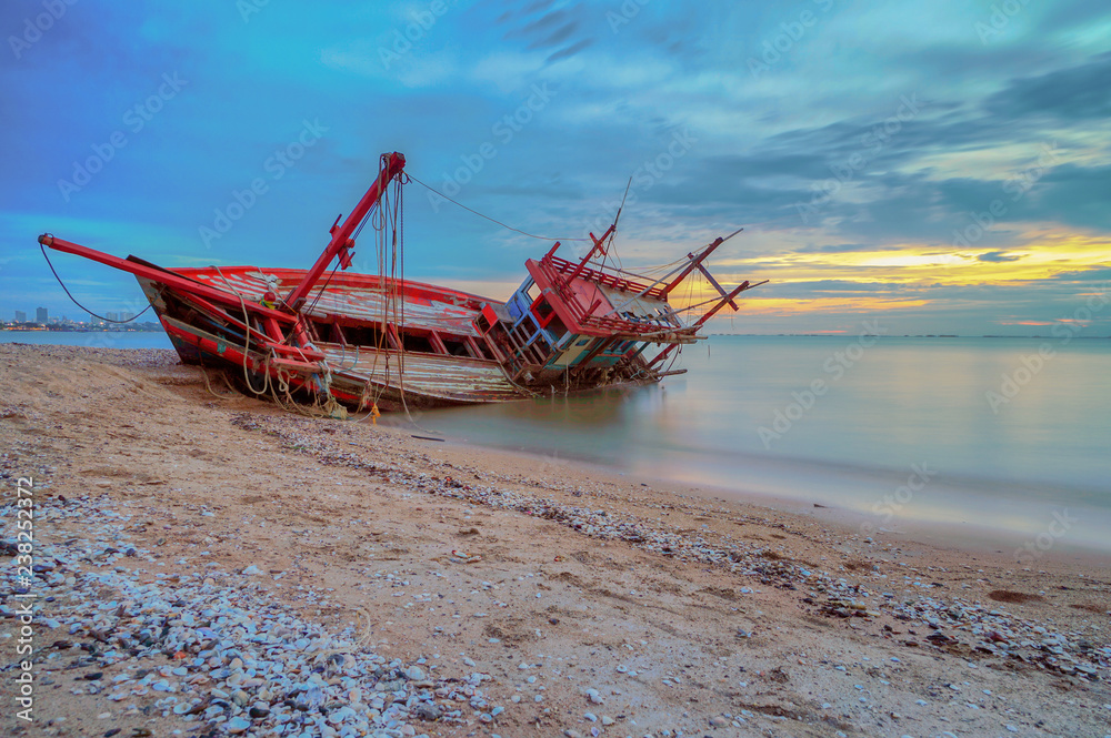 An old shipwreck boat abandoned stand on beach. Shipwreck in Kratinglay beach Chonburi Thailand.