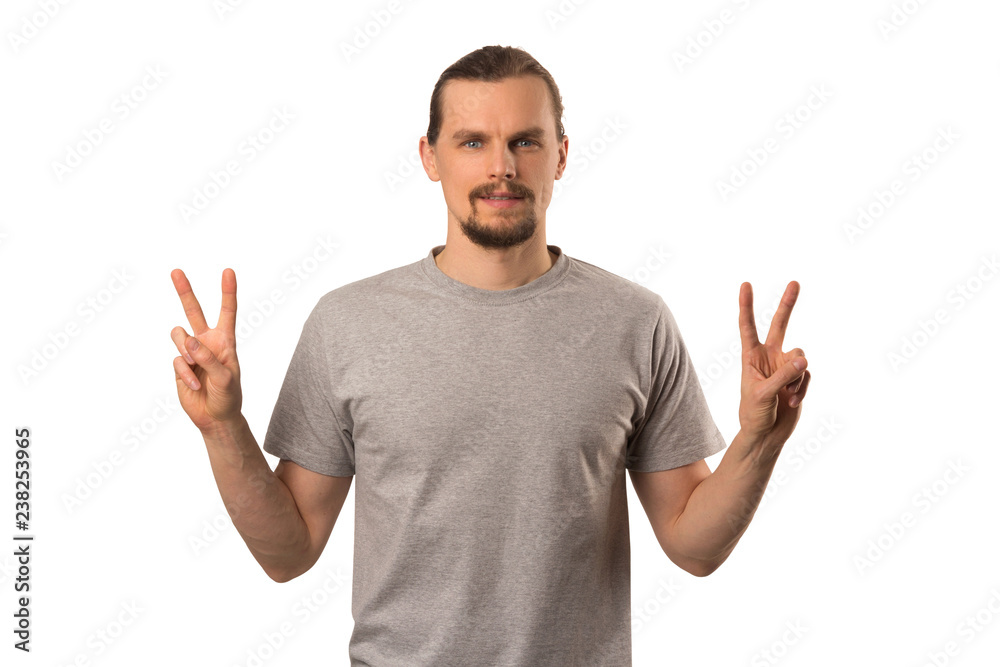 Fototapeta premium Bearded attractive caucasian guy hoding hands with victory sign isolated on white