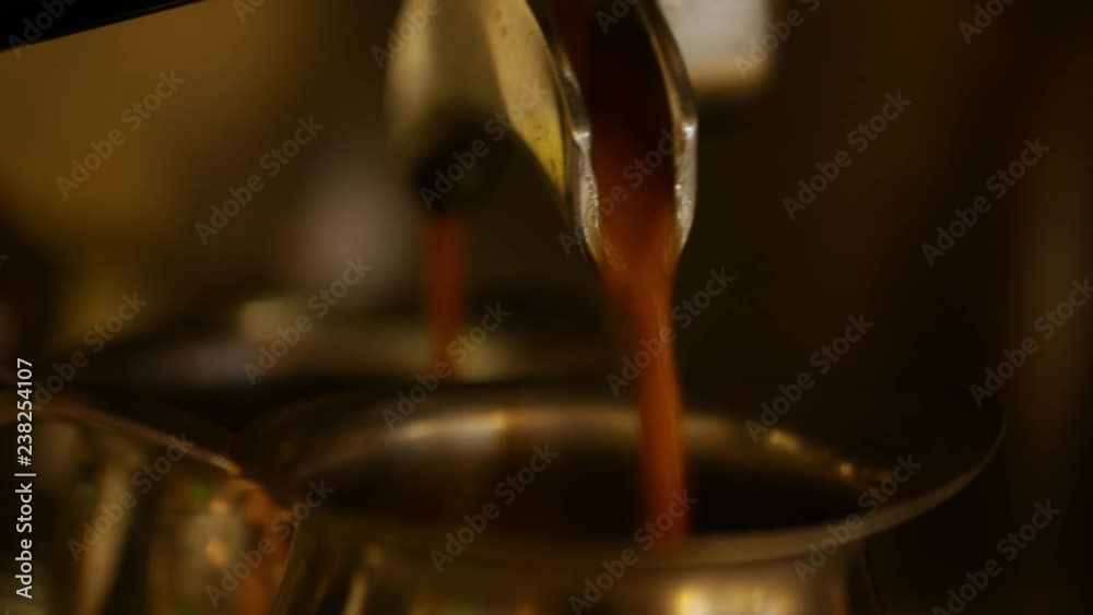 Coffee machine pouring espresso in special metal cups Coffee machine pouring espresso in special metal cups