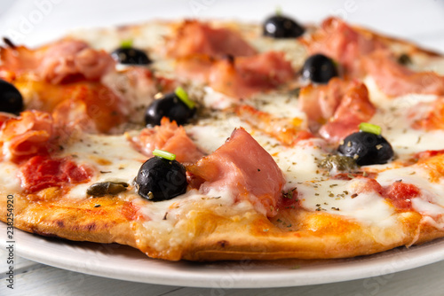 Pizza con prosciutto, olive, mozzarella e sugo