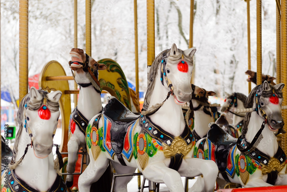 Carousel with rocking horses in the park. Children's carousel is closed for the winter season.