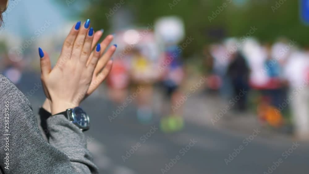 Woman cheering runners and clapping hands in 4k slow motion 60fps
