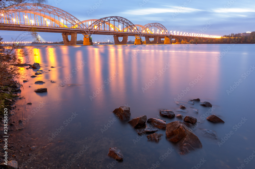 Fototapeta premium Railway bridge over the river. Rosemouth clouds and water.
