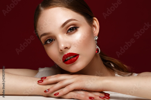 Beautiful girl in red dress with classic make-up and red manicure. Beauty face.
