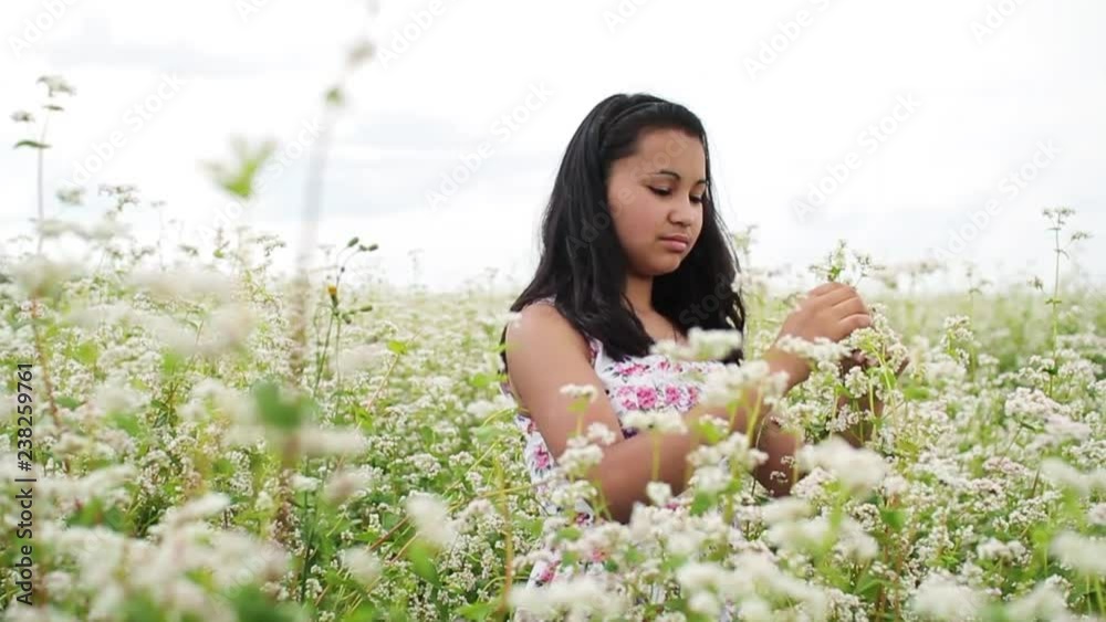 Beautiful young woman in light summer dress enjoying nature and smelling blooming wild flowers.Romantic atmosphere.Dreaming, positive emotions, good mood.Scenic walk. Female portrait Beautiful young woman in light summer dress enjoying nature and smelling blooming wild flowers.Romantic atmosphere.Dreaming, positive emotions, good mood.Scenic walk. Female portrait
