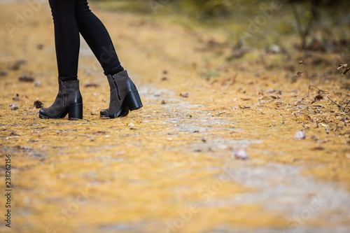 Girl in platform boots walk on autumn path