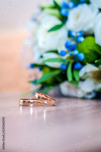Wedding rings on the table next to the bouquet