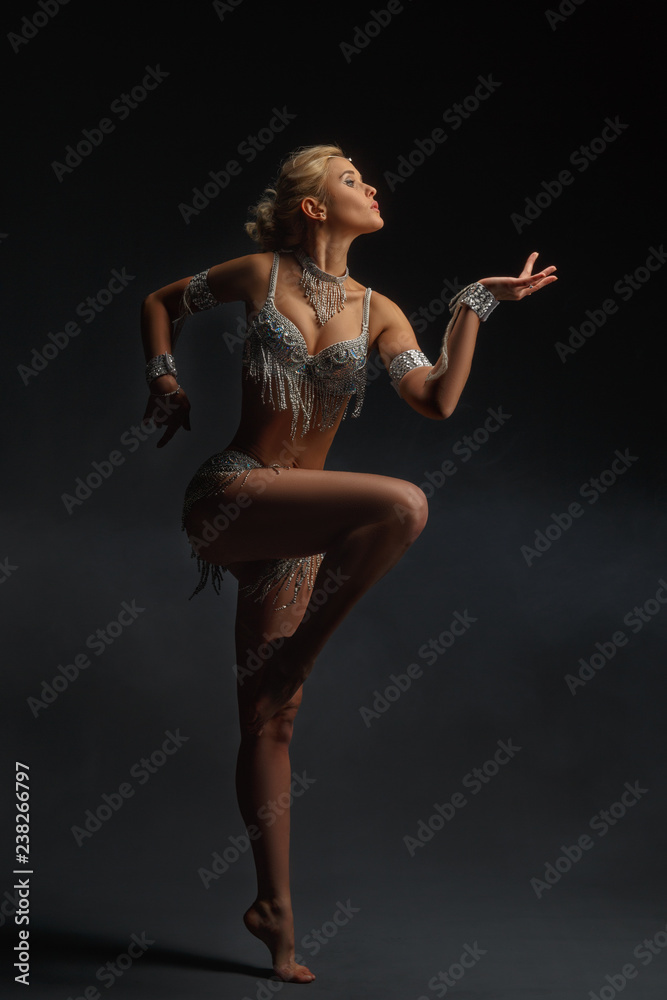 Slender girl blonde in a beautiful costume dancing Oriental dance. Slender girl blonde in a beautiful costume dancing Oriental dance.