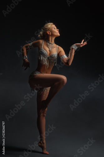 Slender girl blonde in a beautiful costume dancing Oriental dance.