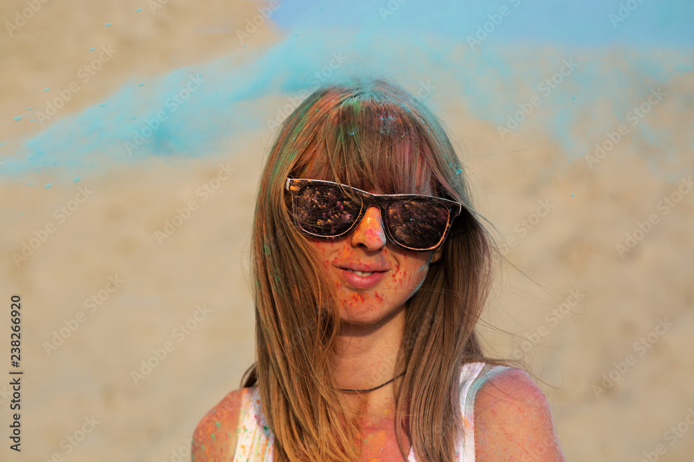 Pretty blonde girl playing with colorful dry paint Holi at the desert Pretty blonde girl playing with colorful dry paint Holi at the desert