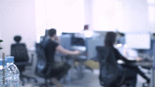 plants and bottles of drinking water in an office with many employees