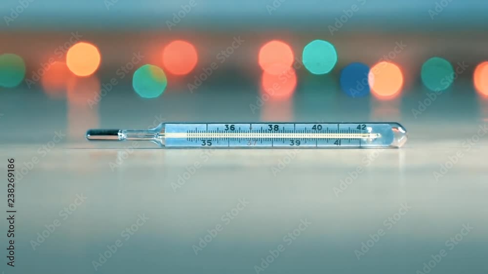 Zoom out shot mercury thermometer and colorful bright lights Zoom out shot mercury thermometer and colorful bright lights