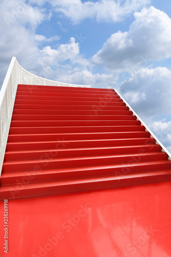 Red carpeted staircase in the clouds