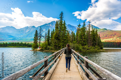 Woman walking along footbridge in Jasper National Park, Canada photo