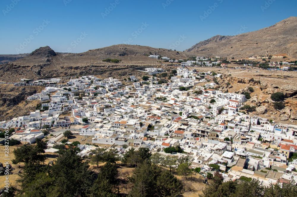 Overview of Lindos, group of white houses one by one, aerial view from Acropolis fortified citadel