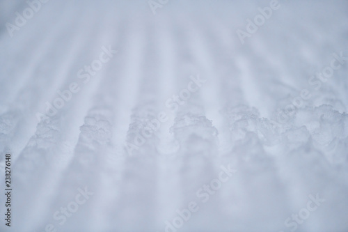 Texture of fresh stripped snowcat traces on snow
