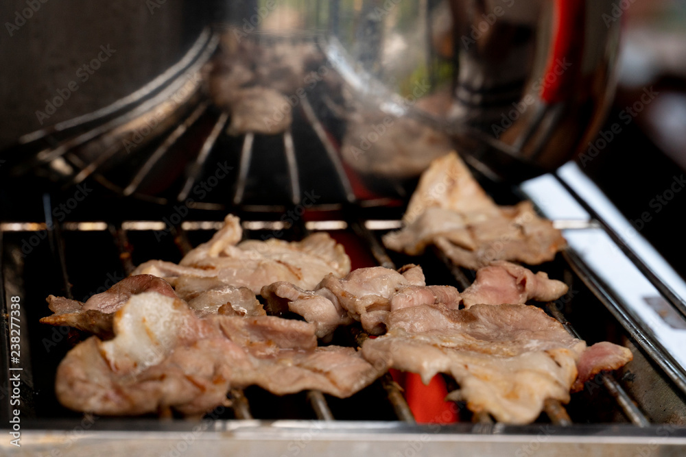 Celebration party roast sliced pork put on hot grill grate. Use heat from the gas.