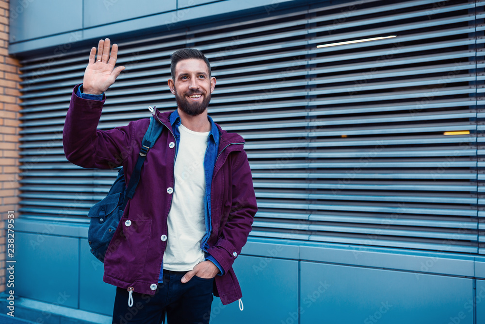 Half length portrait of handsome bearded man dressed in fashionable clothes standing on street. Half length portrait of handsome bearded man dressed in fashionable clothes standing on street.