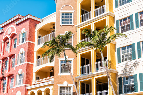 Condos, condominiums colorful, orange yellow multicolored buildings facade exterior with windows, palm trees, real estate property in Spain photo