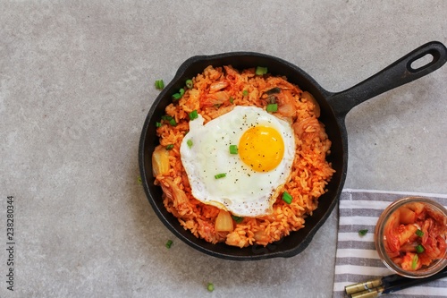 Картината върху платно Homemade Kimchi Fried rice topped with fried egg on skillet, overhead view