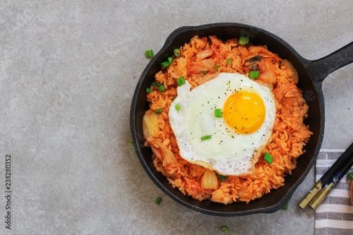 Homemade Kimchi Fried rice topped with fried egg on skillet, overhead view
