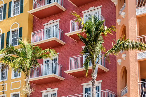 Fototapeta Naklejka Na Ścianę i Meble -  Florida condo, condominium colorful, red multicolored buildings facade exterior with windows, palm trees, real estate property in Spain