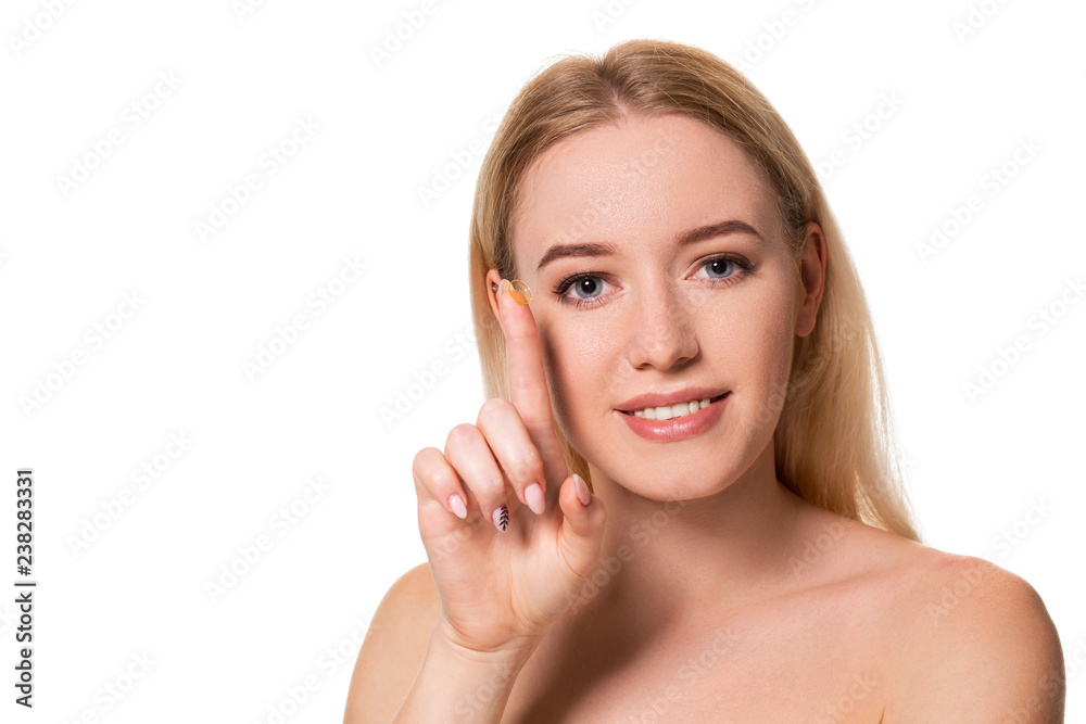 Young woman holding contact lens on index finger with copy space. Close up face of healthy beautiful woman about to wear contact lens. Young woman holding contact lens on index finger with copy space. Close up face of healthy beautiful woman about to wear contact lens.