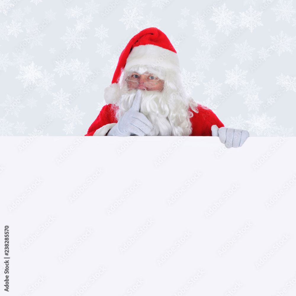 Santa Claus with blank sign making shhh sign  with a light silver background with snow flakes