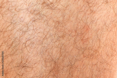 Hairy man's leg, background. Fragment of skin covered with hair, male body.