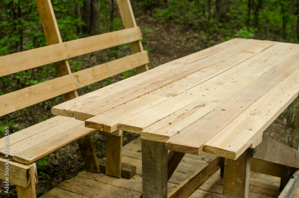 construction of wooden table and benches under canopy with in the forest