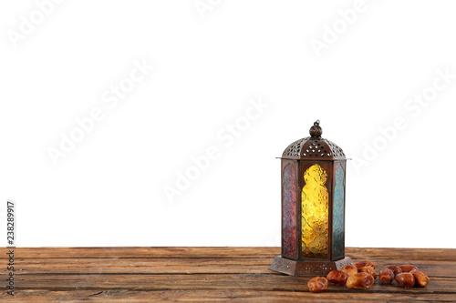 Muslim lamp and dates on wooden table against white background. Space for text