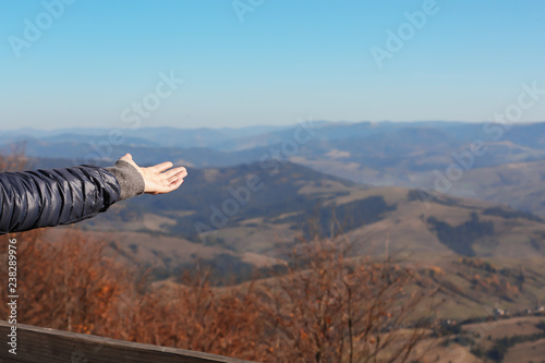 Woman showing beautiful mountain landscape on sunny day