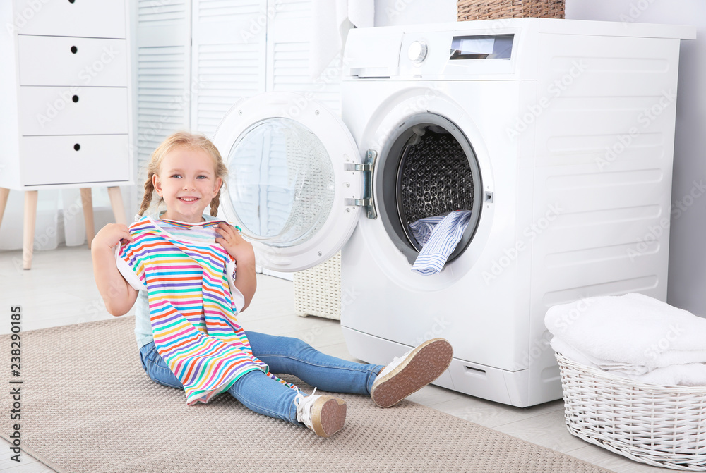 Adorable little girl doing laundry at home Adorable little girl doing laundry at home