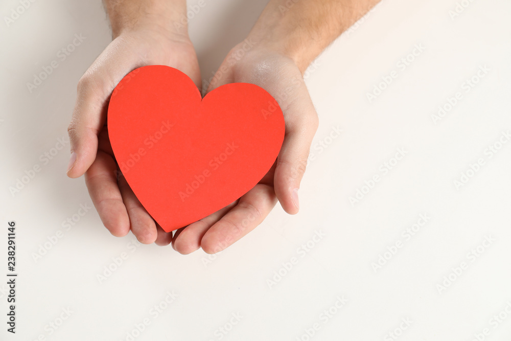 Man holding paper heart on white background, closeup Man holding paper heart on white background, closeup