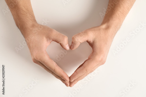 Man making heart with his hands on white background  top view