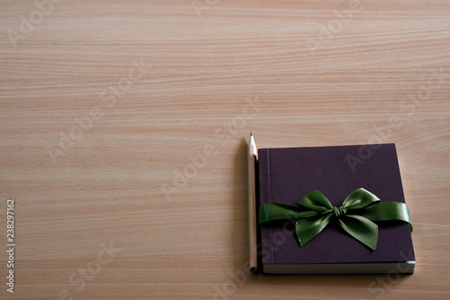 Book diary for gifts to give souvenirs and pencils placed on wooden table.