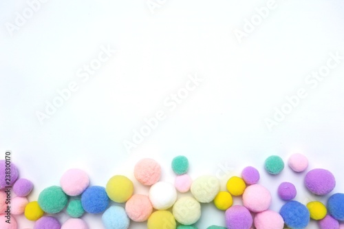 Colorful pom poms on white copy space background 