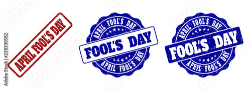 APRIL FOOL'S DAY scratched stamp seals in red and blue colors. Vector APRIL FOOL'S DAY labels with grunge texture. Graphic elements are rounded rectangles, rosettes, circles and text labels.