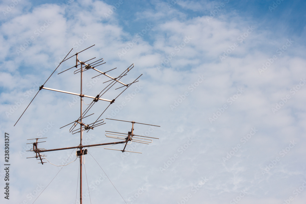 Old house antenna with blue cloudy sky background with copy space, analog TV signal Old house antenna with blue cloudy sky background with copy space, analog TV signal