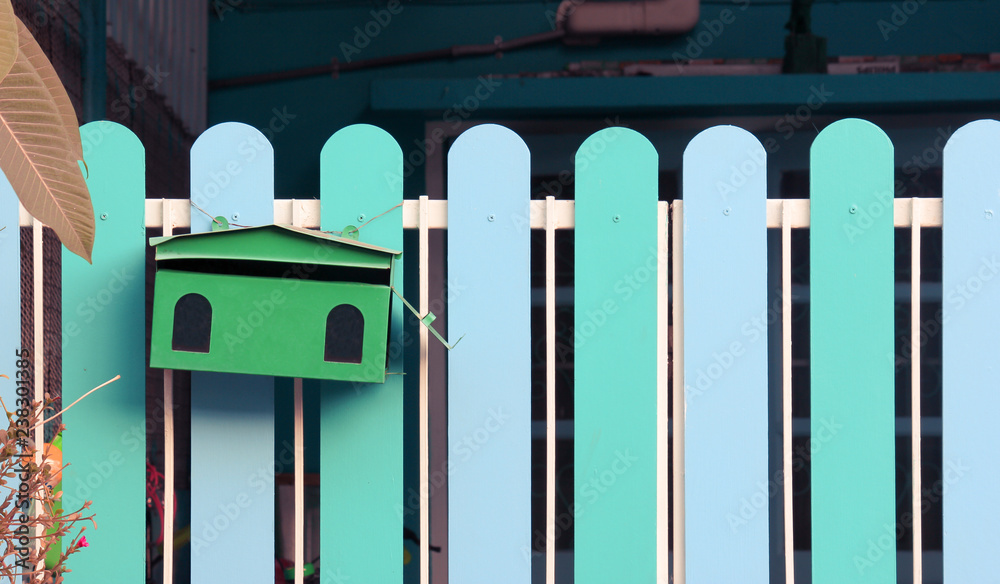 Empty green mailbox on the blue fences door background with copy space