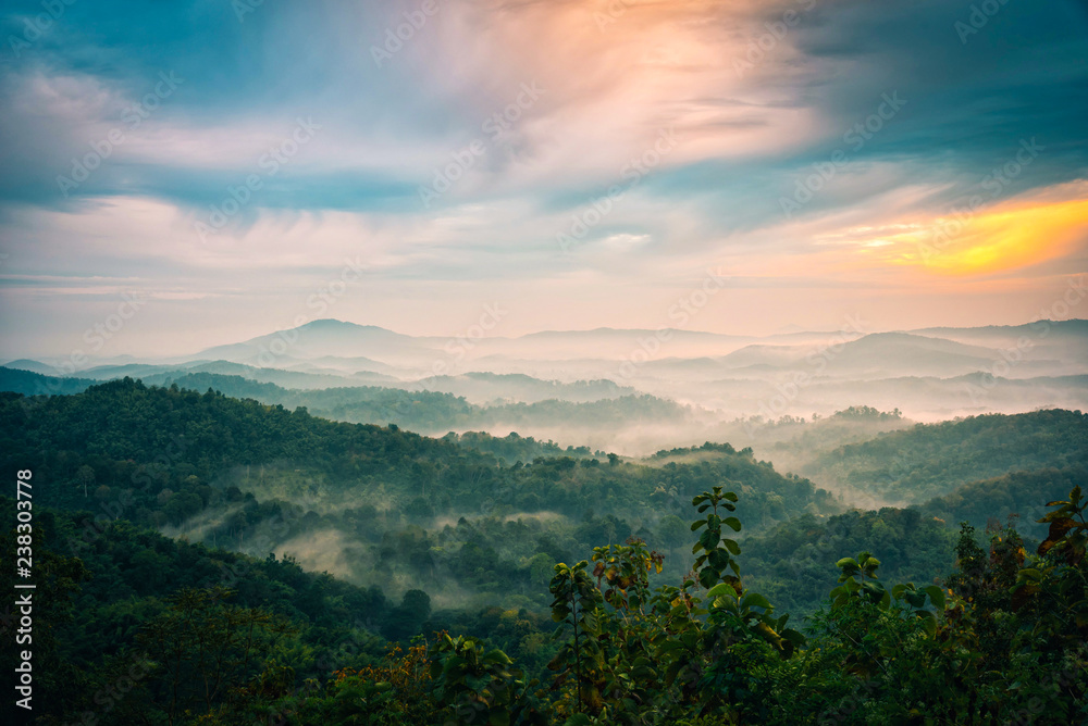 Obraz premium Foggy in the mountains with dramatic sky at sunrise
