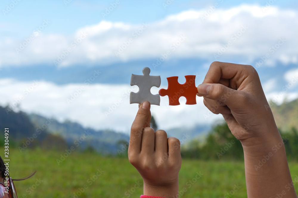 hands holding piece ofjigsaw puzzle. teamwork concept hands holding piece ofjigsaw puzzle. teamwork concept