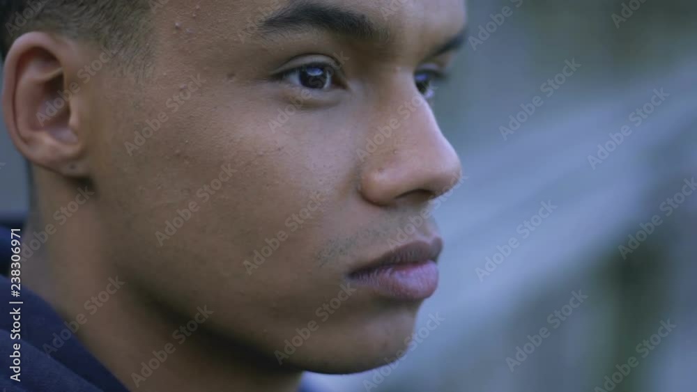 Depressed african-american guy thinking about his life, lonely sitting outdoor Depressed african-american guy thinking about his life, lonely sitting outdoor